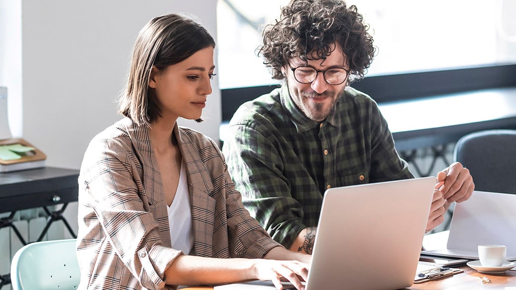 CORP-Man-and-Woman-in-Office-Working-on-a-Laptop.jpg